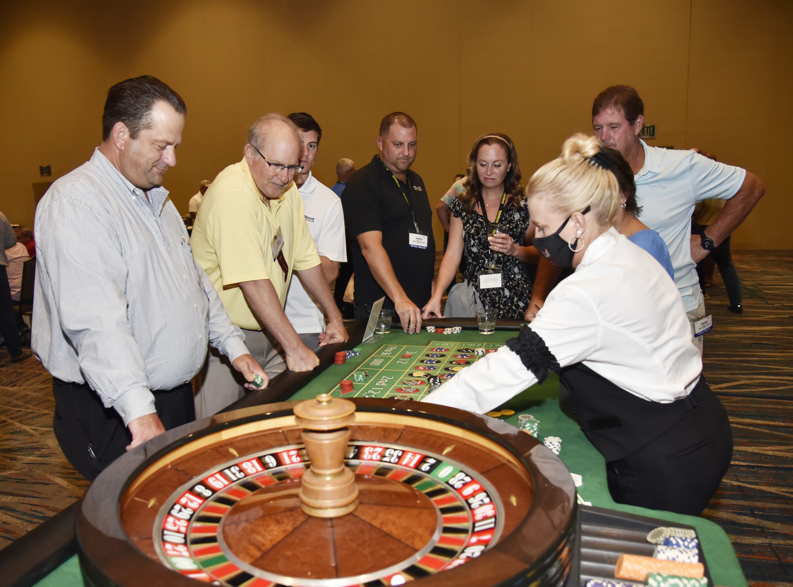 FBMA members gathering around a roulette table for Vegas Night.